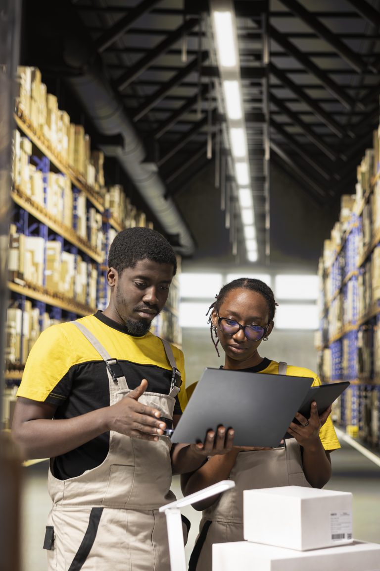 black employees checking inventory and shipment details on laptop